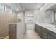 Modern bathroom featuring a glass-enclosed shower and double vanity with quartz countertops at 17767 W Getty Dr, Goodyear, AZ 85338