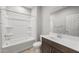 A bright bathroom features a shower-tub combo and a single sink vanity with dark wood cabinets at 17767 W Getty Dr, Goodyear, AZ 85338