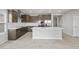 A modern, open-concept kitchen features a center island, stainless steel appliances, and dark wood cabinets at 17767 W Getty Dr, Goodyear, AZ 85338