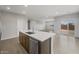 Open-concept kitchen featuring a large island with a stainless steel sink and modern faucet at 17767 W Getty Dr, Goodyear, AZ 85338