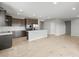 Open-concept kitchen with dark cabinets, stainless steel appliances, and large central island at 17767 W Getty Dr, Goodyear, AZ 85338