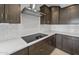 Modern kitchen with white subway tile backsplash, stainless steel vent hood, and smooth cooktop at 17767 W Getty Dr, Goodyear, AZ 85338