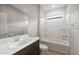 Clean, well-lit bathroom with a shower-tub combination, dark wood vanity and sink, and a tiled floor at 17770 W Getty Dr, Goodyear, AZ 85338
