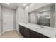 Bright bathroom featuring double sink vanity and a large mirror reflecting a modern shower at 17770 W Getty Dr, Goodyear, AZ 85338