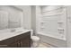 Well-lit bathroom with a shower-tub combination, dark wood vanity and sink, and a tiled floor at 17770 W Getty Dr, Goodyear, AZ 85338