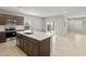 Open-concept kitchen with dark wood cabinets, white countertops, stainless steel appliances, and island seating at 17770 W Getty Dr, Goodyear, AZ 85338