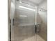 Modern tiled shower with glass door and a built-in shelf at 17770 W Getty Dr, Goodyear, AZ 85338