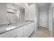 Bright bathroom with double sinks, stone countertops, and a glass shower enclosure at 17779 W Getty Dr, Goodyear, AZ 85338