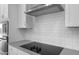 Close-up on the modern cooktop with range hood, and subway tile backsplash at 17779 W Getty Dr, Goodyear, AZ 85338