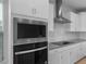 Close-up of modern stainless steel oven and cooktop, with white subway tile backsplash at 17779 W Getty Dr, Goodyear, AZ 85338