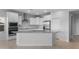 Stylish kitchen featuring white cabinetry, stainless steel appliances, and a gray countertop island at 17779 W Getty Dr, Goodyear, AZ 85338