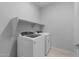 Laundry room with new washer and dryer and built-in shelving at 17779 W Getty Dr, Goodyear, AZ 85338