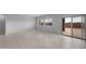 Spacious living room featuring light-colored tile flooring and sliding glass doors at 17779 W Getty Dr, Goodyear, AZ 85338