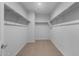 Empty walk-in closet with shelves, carpeted floor, and white walls at 17779 W Getty Dr, Goodyear, AZ 85338