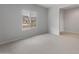 A bright bedroom with a window allowing natural light to fill the room and neutral carpet flooring at 17791 W Getty Dr, Goodyear, AZ 85338
