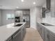 Modern kitchen with stainless steel appliances, island, quartz countertops, and designer backsplash at 17791 W Getty Dr, Goodyear, AZ 85338