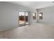Neutral living area featuring a sliding glass door and multiple windows with blinds at 17791 W Getty Dr, Goodyear, AZ 85338