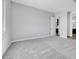 A light-filled bedroom with neutral walls and plush carpet leads to bathroom and a walk-in closet at 18147 W Tanglewood Dr, Goodyear, AZ 85338