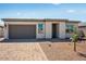 Charming single-story home featuring a gray garage door and desert landscaping at 18147 W Tanglewood Dr, Goodyear, AZ 85338