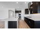 Contemporary kitchen boasts dark cabinets, a stainless range hood, and a spacious island at 18147 W Tanglewood Dr, Goodyear, AZ 85338