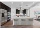 Modern kitchen featuring dark cabinetry, stainless appliances, and seating at the island at 18147 W Tanglewood Dr, Goodyear, AZ 85338