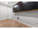 The laundry room features sleek, dark cabinets and wood-look floors at 18147 W Tanglewood Dr, Goodyear, AZ 85338