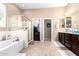 Open bathroom featuring walk-in shower, soaking tub, double vanity, and natural light at 18543 W Denton Ave, Litchfield Park, AZ 85340