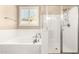 Bright bathroom featuring a soaking tub, glass-enclosed shower, and tiled walls at 18543 W Denton Ave, Litchfield Park, AZ 85340