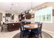 Bright kitchen with dark cabinetry, stainless steel appliances, a granite island, and an adjacent dining area at 18543 W Denton Ave, Litchfield Park, AZ 85340