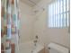 Bright bathroom featuring a shower-tub combo, patterned wallpaper, and a large window at 2009 N 125Th Ave, Avondale, AZ 85392