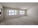 Spacious living room with soft carpeting and large windows offering plenty of natural light at 2009 N 125Th Ave, Avondale, AZ 85392