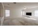 Open living room featuring neutral paint, a ceiling fan, multiple windows, and wall-mounted television at 2009 N 125Th Ave, Avondale, AZ 85392