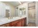Bathroom featuring a double vanity, a large mirror, and a shower and toilet enclosure at 20802 N Grayhawk Dr # 1005, Scottsdale, AZ 85255