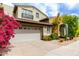 Charming two-story home featuring a two-car garage and vibrant bougainvillea bushes at 20802 N Grayhawk Dr # 1005, Scottsdale, AZ 85255