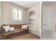 Cozy hallway nook with a rustic wooden bench, decorative pillows, and natural light at 20802 N Grayhawk Dr # 1005, Scottsdale, AZ 85255