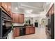 Spacious kitchen featuring wood cabinetry, black appliances and tiled flooring with an open layout concept at 20802 N Grayhawk Dr # 1005, Scottsdale, AZ 85255