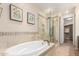 Spa-like main bathroom featuring a soaking tub, glass-enclosed shower, and tile accents at 20802 N Grayhawk Dr # 1005, Scottsdale, AZ 85255