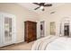 Stylish main bedroom with an armoire, ceiling fan, and a door leading to a balcony at 20802 N Grayhawk Dr # 1005, Scottsdale, AZ 85255