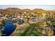 Stunning aerial view of a community with lakes, a golf course, and mountain views in the background at 21121 N 63Rd Dr, Glendale, AZ 85308