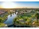 Scenic aerial view of a community with a golf course, lakes, and lush green landscaping at 21121 N 63Rd Dr, Glendale, AZ 85308