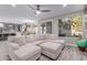 Bright living room with a sectional sofa, tile floors, and large windows overlooking the outdoor living area at 21121 N 63Rd Dr, Glendale, AZ 85308