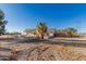 The exterior back of the home featuring desert landscaping, an outdoor seating area, and fenced yard at 22324 W Magnolia St, Buckeye, AZ 85326