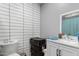 Modern bathroom featuring sleek white tile, a white vanity, and a modern mirror at 22324 W Magnolia St, Buckeye, AZ 85326
