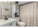 Bright bathroom features a vanity, toilet, and shower with a ruffled curtain, creating a clean and functional space at 22324 W Magnolia St, Buckeye, AZ 85326