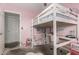 Pink bedroom featuring a loft bed with a built-in desk, offering a playful and functional space at 22324 W Magnolia St, Buckeye, AZ 85326