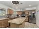 Functional kitchen featuring an island, stainless steel appliances, and tile countertops at 22324 W Magnolia St, Buckeye, AZ 85326