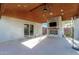 Spacious covered patio with a stone fireplace, outdoor speakers, and ceiling fan, ideal for outdoor gatherings at 22324 W Magnolia St, Buckeye, AZ 85326