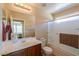 Bright bathroom featuring a vanity with a solid surface countertop, framed mirror, and a shower-tub combination with glass doors at 2464 E Hancock Trl, Casa Grande, AZ 85194