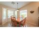 Sunny dining room features a wood table with seating for six and large windows at 2464 E Hancock Trl, Casa Grande, AZ 85194