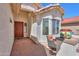 Cozy front porch with brick pavers, comfortable seating, and a decorative planter, perfect for relaxing and enjoying the outdoors at 2464 E Hancock Trl, Casa Grande, AZ 85194